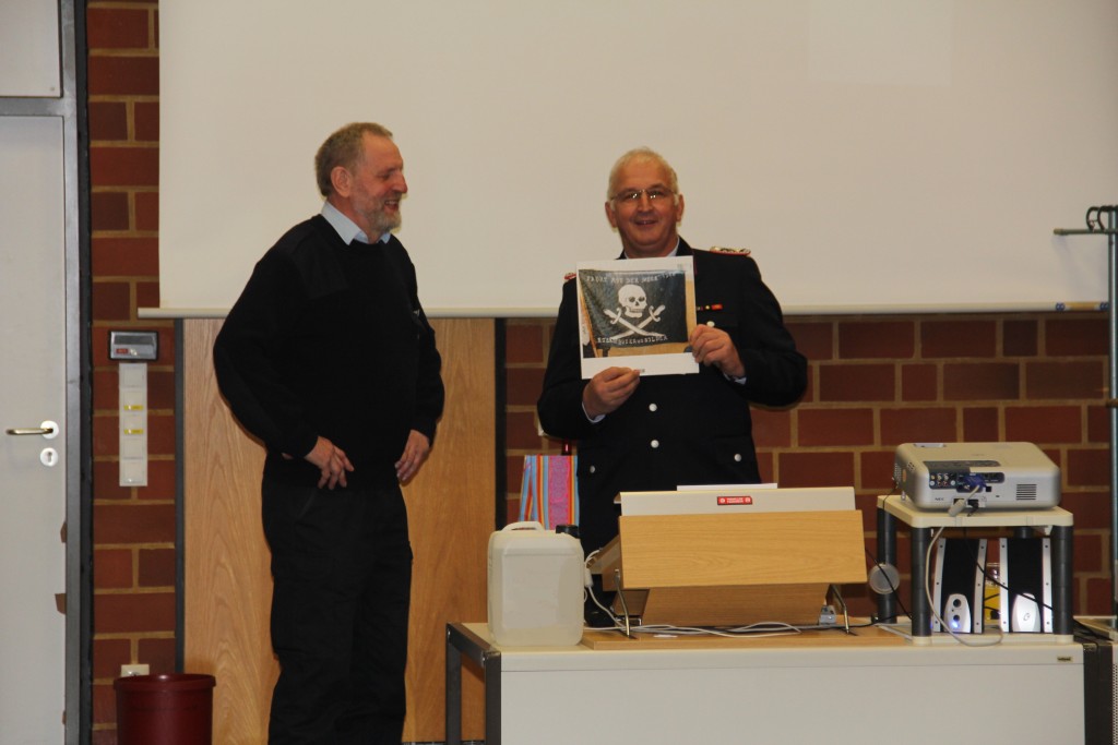 Lehrgangsleiter Harald Cordes übergibt an Dieter Tönjes (links) ein Fotobuch mit Erinnerunggsfotos von den Lehrgängen